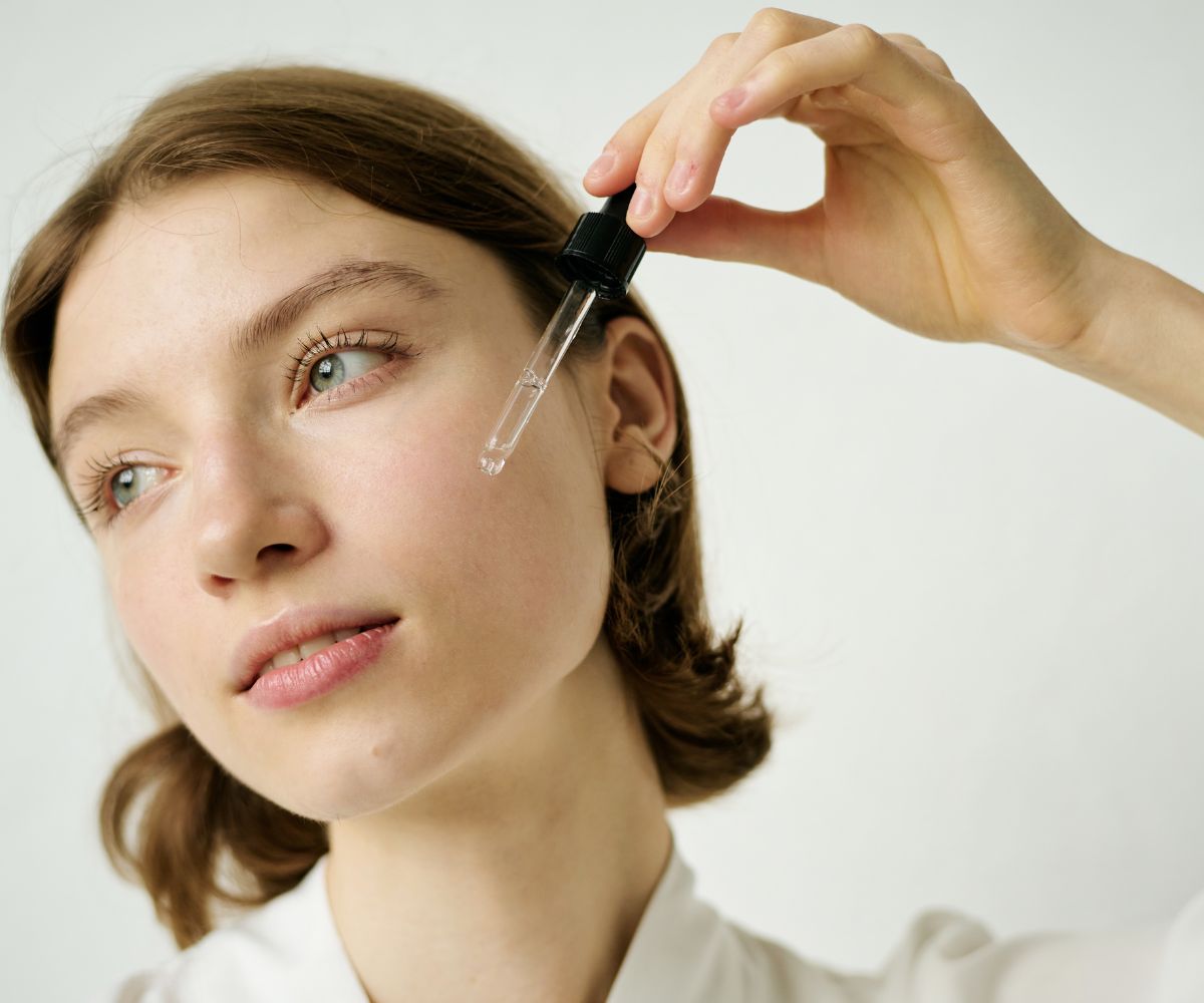 El retinol se ha convertido en uno de los ingredientes estrella de las rutinas antiedad, pero cuando llega el verano aparece siempre la misma duda: ¿hay que guardarlo hasta septiembre? La respuesta no es tan sencilla como un sí o un no. El retinol en verano puede formar parte de determinadas rutinas, pero requiere más atención, especialmente si la piel está expuesta al sol con frecuencia. Este derivado de la vitamina A cuenta con evidencia detrás de su capacidad para mejorar algunos signos del envejecimiento, la textura y determinadas alteraciones de la piel. Sin embargo, también puede provocar irritación, sequedad o sensibilidad, sobre todo cuando se empieza a utilizar. Por este motivo, el verano no es necesariamente el momento ideal para experimentar por primera vez con él. ¿Se puede utilizar retinol en verano? Sí, pero con matices. El problema no es simplemente que sea verano, sino la combinación entre un activo que puede irritar la piel y una exposición solar más intensa y frecuente. Si ya llevas tiempo utilizando retinol y tu piel lo tolera bien, un dermatólogo puede considerar adecuado mantenerlo durante los meses de verano ajustando la rutina. En cambio, si nunca lo has utilizado, comenzar durante unas vacaciones llenas de días de playa y piscina probablemente no sea la mejor idea. Así que no se trata de demonizar el retinol en verano, sino de saber cuándo y cómo utilizarlo. La fotoprotección es obligatoria Si hay una regla que no admite discusión es la importancia de utilizar un protector solar de amplio espectro. La exposición solar es uno de los principales factores relacionados con el fotoenvejecimiento y la aparición de manchas. Además, una piel irritada tolera peor las agresiones externas. Por tanto, si utilizas retinoides, la protección solar diaria debe formar parte de la rutina incluso cuando no vayas a la playa. En días de exposición intensa, conviene utilizar un factor elevado y reaplicarlo según las recomendaciones del producto y la situación. ¿Y qué pasa si voy a la playa? Aquí conviene ser todavía más prudente. Si vas a pasar varias horas tomando el sol, bañándote y realizando actividades al aire libre, puede ser razonable consultar con un dermatólogo sobre la conveniencia de pausar temporalmente el tratamiento. Algunas recomendaciones dermatológicas actuales plantean precisamente adaptar o interrumpir el tratamiento durante periodos de exposición solar intensa. Además, el verano ofrece muchas alternativas para cuidar la piel sin sobrecargarla con demasiados activos. Cómo adaptar tu rutina de skincare Durante los meses más calurosos puede ser buena idea simplificar la rutina. Por la mañana, una limpieza suave, hidratación y fotoprotección pueden ser suficientes para muchas pieles. Por la noche, si mantienes el retinol, utiliza la cantidad y frecuencia que tu piel ya tolera y evita combinarlo alegremente con otros activos potencialmente irritantes. Ingredientes como el ácido hialurónico o productos destinados a reforzar la barrera cutánea pueden complementar la rutina. Por este motivo, menos productos no significa necesariamente peor cuidado. ¿Qué ocurre si aparecen rojeces o descamación? La irritación no debe interpretarse como una señal de que el producto está funcionando mejor. Si aparecen enrojecimiento, escozor, descamación intensa o sensación de quemazón, conviene reducir la frecuencia o suspender el producto y consultar con un profesional si las molestias persisten. Además, aplicar más cantidad de retinol no acelera los resultados. La piel necesita tiempo para adaptarse y los resultados de estos activos se consiguen con constancia, no con aplicaciones excesivas. ¿Es mejor utilizarlo por la noche? Sí. El retinol suele incorporarse a la rutina nocturna. De esta forma, la rutina de mañana puede centrarse en proteger la piel de la radiación solar y mantener una buena hidratación. Además, utilizarlo por la noche facilita separar el tratamiento de otros productos destinados a la protección solar. El retinol no es el único activo que existe Si durante el verano notas que tu piel está más sensible, no tienes por qué forzar una rutina con numerosos activos. Una buena hidratación, antioxidantes y protección solar pueden ser suficientes para mantener la piel cuidada mientras reduces temporalmente la intensidad de algunos tratamientos. Después del verano, cuando la exposición solar intensa disminuya, puedes volver a revisar la rutina con ayuda de un dermatólogo o profesional cualificado. Entonces, ¿hay que abandonar el retinol en verano? No necesariamente. El debate sobre el retinol en verano ha cambiado porque cada vez se insiste más en diferenciar entre abandonar automáticamente el activo y adaptarlo a las circunstancias. Si tu piel lo tolera, puedes recibir asesoramiento profesional y mantienes una fotoprotección adecuada, quizá no tengas que renunciar a él. Pero si vas a pasar el verano al sol, acabas de empezar a utilizarlo o tu piel está irritada, lo más sensato es extremar las precauciones. Porque en skincare, especialmente en verano, la mejor rutina no es la que acumula más activos, sino la que tu piel puede tolerar y mantener de forma constante.